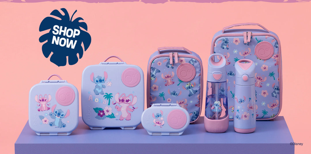 Two children sitting on a purple block holding Disney Stitch themed water bottles, with matching patterned lunch bags on either side, against a pink and purple studio background with Disney Stitch branding and 'Aloha' text.