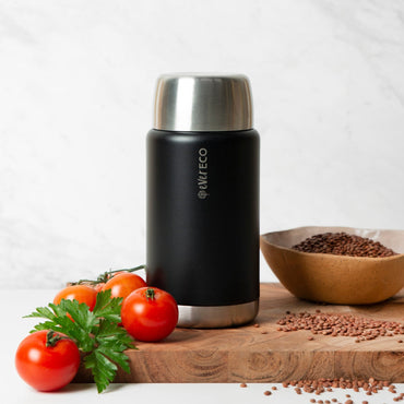 Ever Eco Onyx 800ml insulated food jar thermos with silver top on a wooden cutting board with tomatoes and seeds.