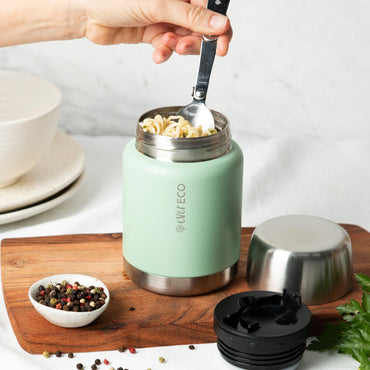 Ever Eco Sage Insulated Food Jar with silver lid being used to scoop food from a bowl on a wooden cutting board.
