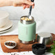 Ever Eco Sage Insulated Food Jar with silver lid being used to scoop food from a bowl on a wooden cutting board.