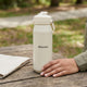 Oasis Ceramic Lined Stainless Steel Capri Drink Bottle 750ml cream personalised bottle on wooden outdoor table with clear cap.