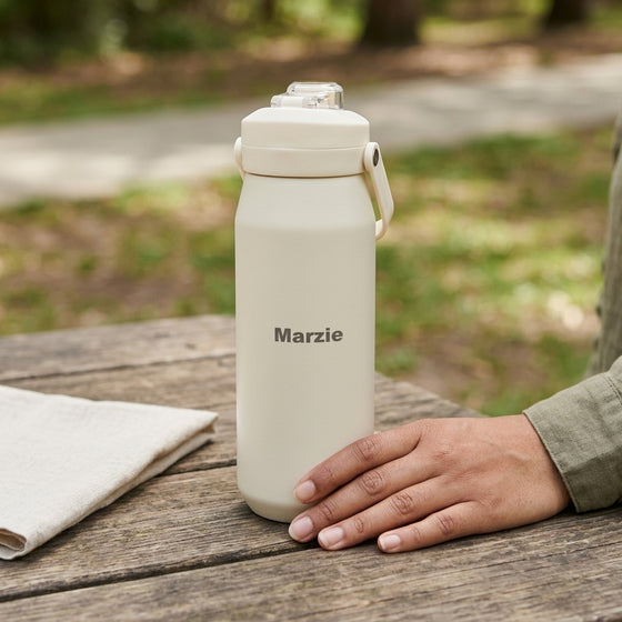 Oasis Ceramic Lined Stainless Steel Capri Drink Bottle 750ml cream personalised bottle on wooden outdoor table with clear cap.