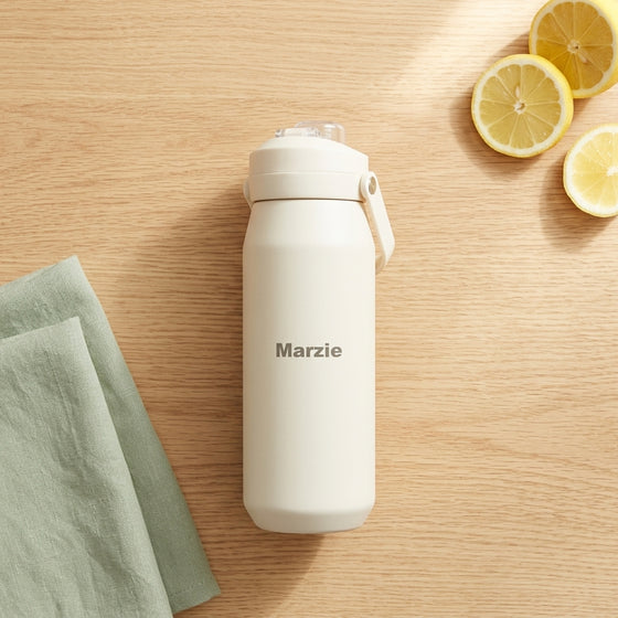 Oasis Ceramic Lined Stainless Steel Capri Drink Bottle 750ml cream personalised bottle on wooden table with lemon slices.